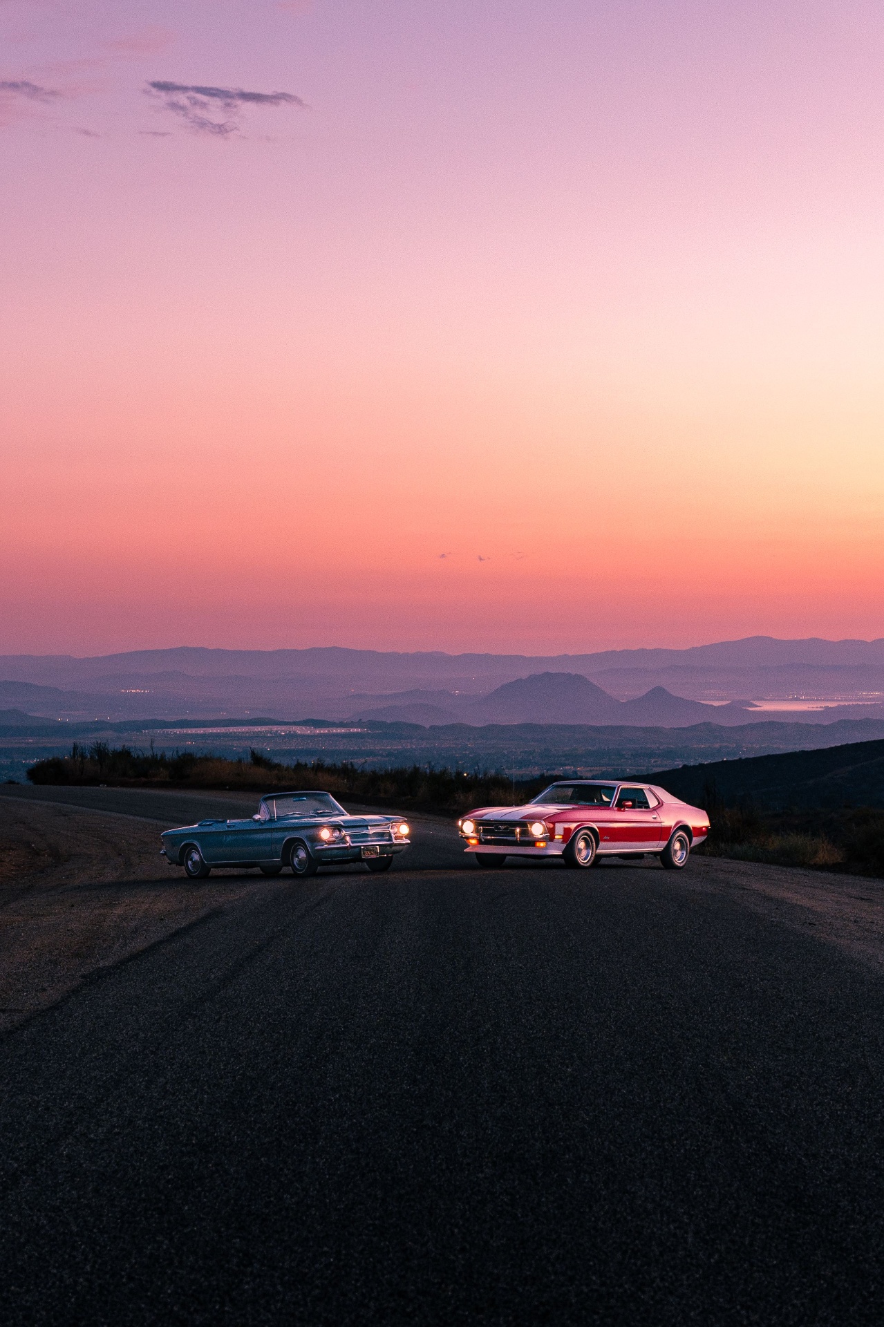 Classic cars meeting at sunset on a California coastal road